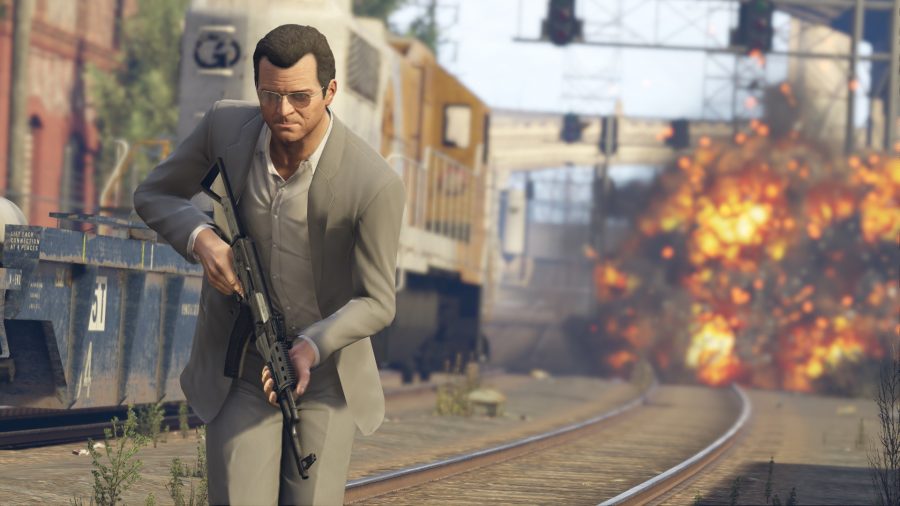 Michael from GTA 5 sports an AK47 while an explosion happens in the background