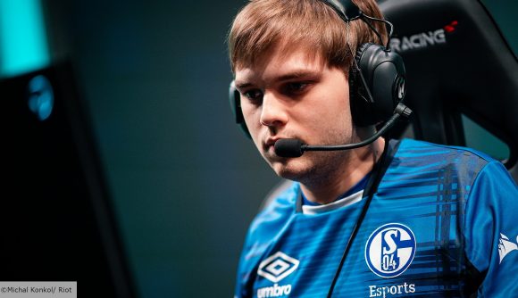 Schalke player Abbedagge wearing a blue jersey and black headset, looking at a PC monitor