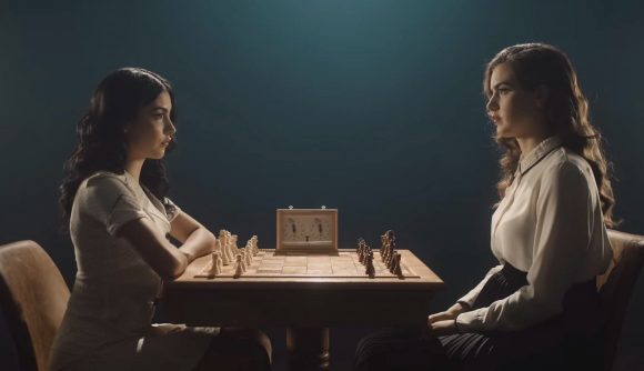 Two chess streamers sat face to face over a chess board, staring each other down
