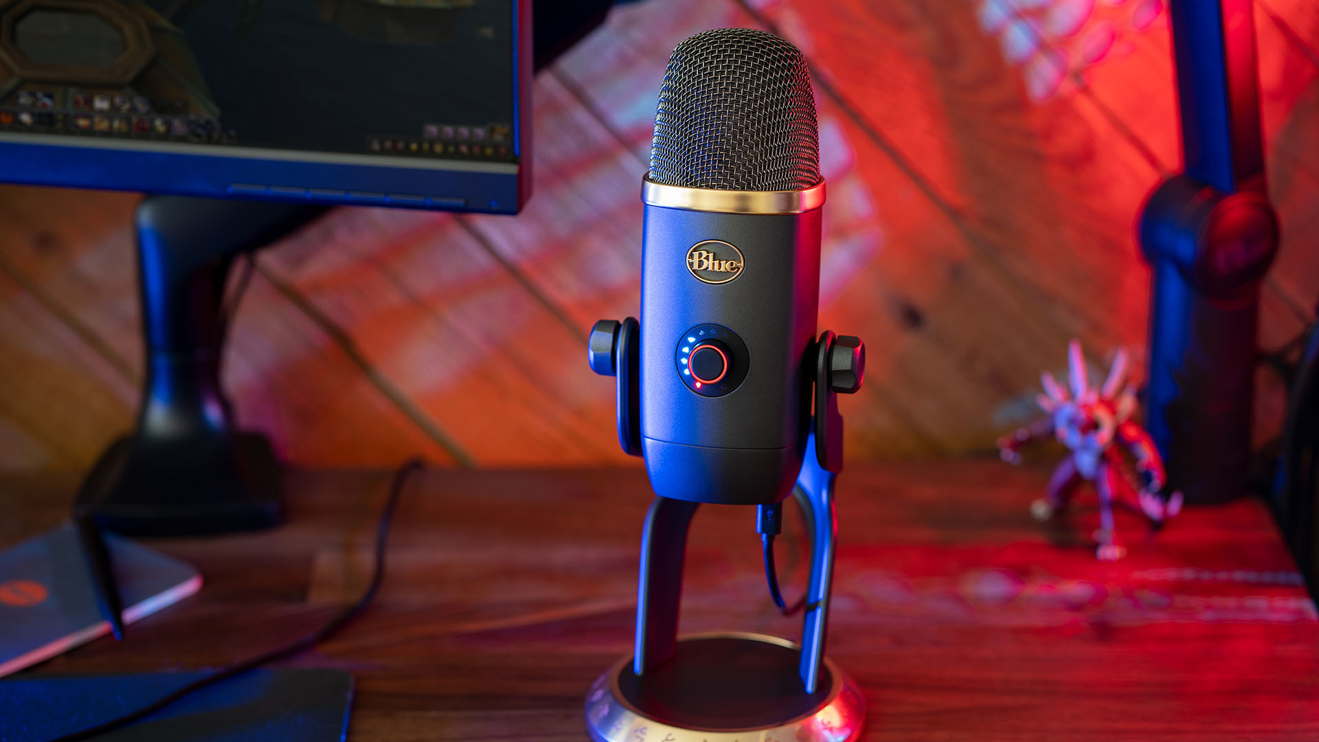 Best microphone for streaming: A blue microphone sits on a desk next to a monitor