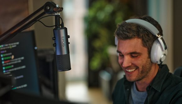 A streamer wearing a silver headset talking into an EPOS microphone attached to a mic arm