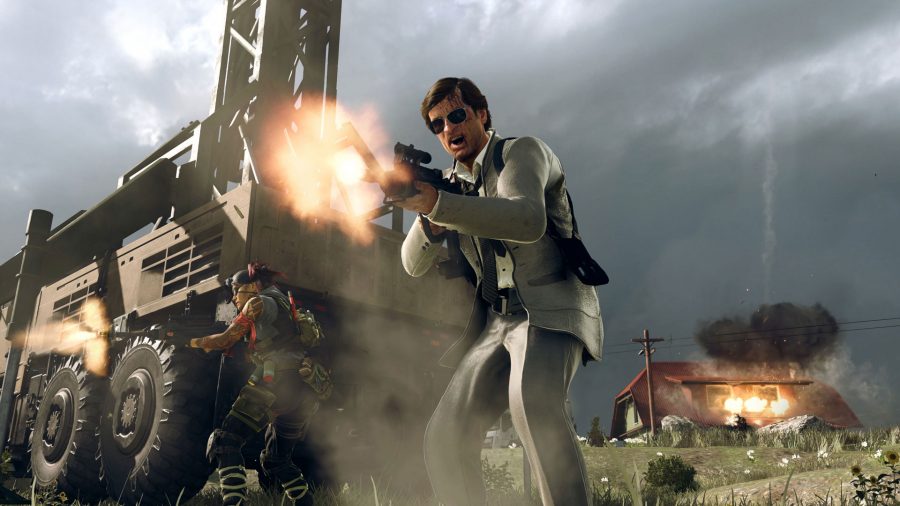 Adler in a white suit screams as he fires a gun in front of a Warzone Mobile station