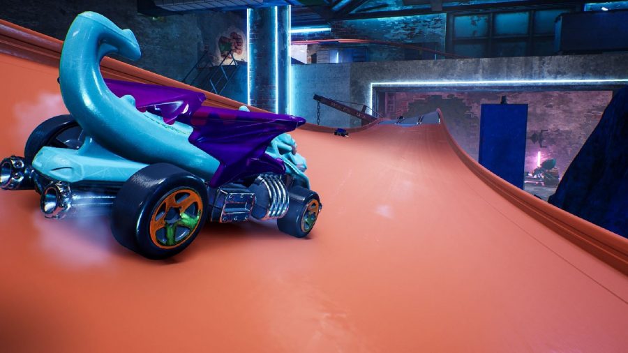 A car shaped as a bright blue dragon with purple wings is driving along a straight part of track. 
