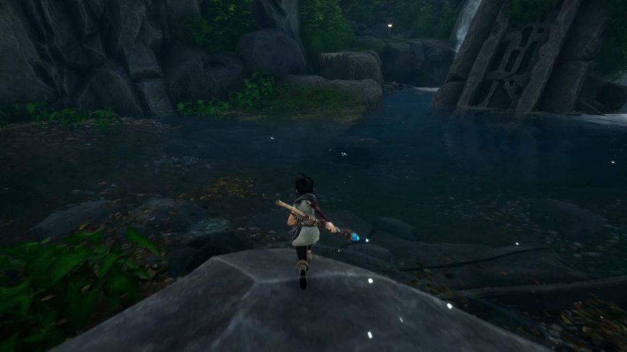 Kena is running towards the ledges in the water leading up to the Rot.