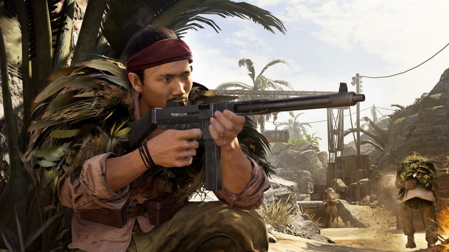 Melhores armas de Warzone: Um operador se agacha atrás de uma palmeira no mapa Caldera de Warzone com sua arma em punho