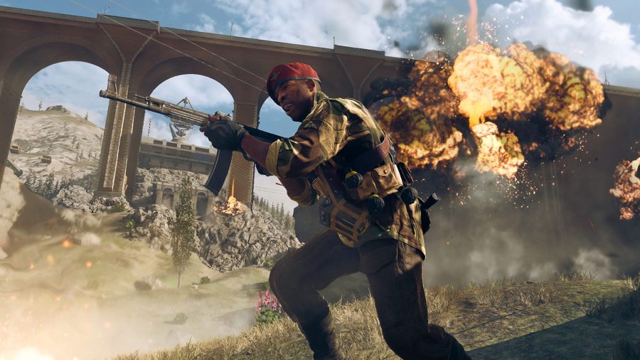 Warzone Secrets of the Pacific locations: A WW2-era soldier in a red military cap charges with an assault rifle in hand. Behind him, an explosion goes off