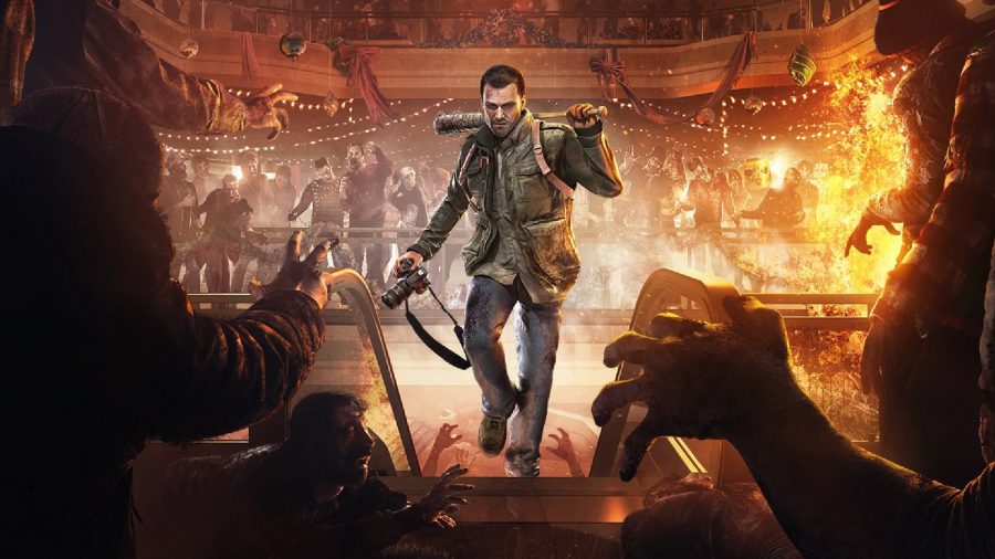 Xbox Games With Gold December 2021: Frank can be seen walking through a burning theatre with zombies around him.
