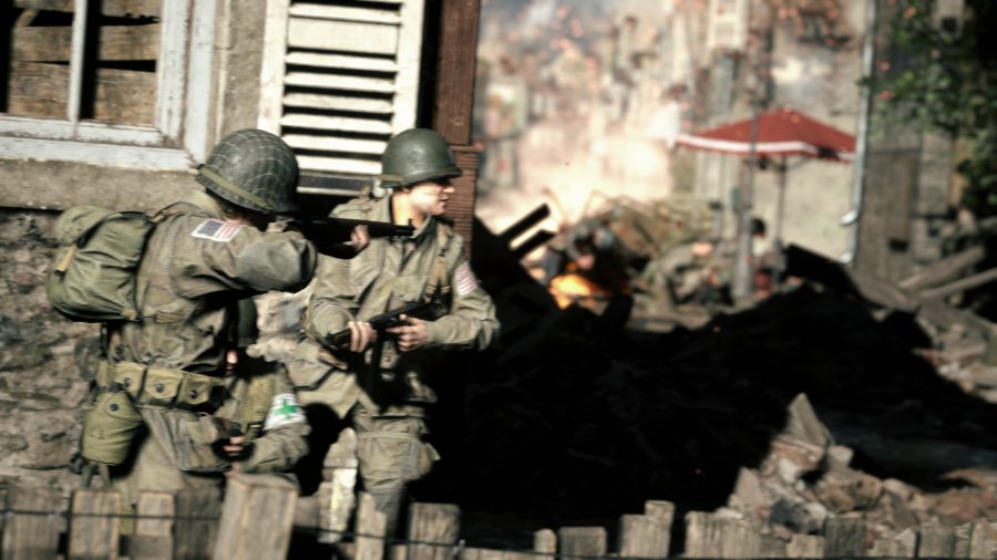 Hell Let Loose 2022: Two American soldiers peer round the corner of a building