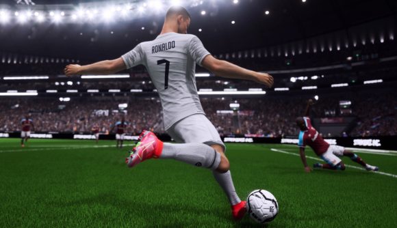 Gameplay from UFL showing Cristiano Ronaldo in a white kit gearing up to strike the ball. A defender slides to block the shot