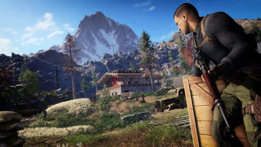 Sniper Elite 5 Best Skills: Karl can be seen walking through a large open field, with a house in the background.