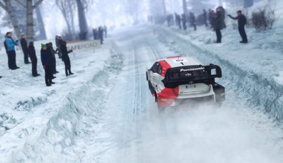 WRC Generations: A car can be seen racing through a snowy hillside with people watching